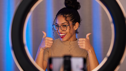 Creator filming with a phone and ring light